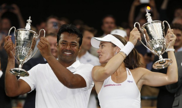 Leander Paes of India, left, and Martina Hingis of Switzerland hold up the trophies after winning t...