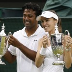 
              Leander Paes of India, left, and Martina Hingis of Switzerland hold up the trophies after winning the mixed doubles final against Alexander Peya of Austria and Timea Babos of Hungary at the All England Lawn Tennis Championships in Wimbledon, London, Sunday July 12, 2015. (AP Photo/Alastair Grant)
            