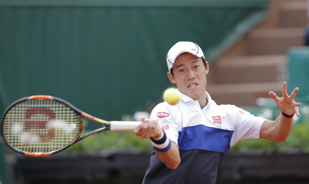 Japan’s Kei Nishikori returns the ball to France’s Paul-Henri Mathieu during their firs...