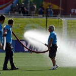 
              FILE - In this June 22, 2015, file photo, workers hose down the artificial field during half time of a second round soccer game between England and Norway at the FIFA Women's World Cu in Ottawa, Ontario, Canada. The fields are heating up, there are little black rubber pellets everywhere, and feet are covered with blisters.  The use of artificial turf at this year’s tournament in Canada has been a contentious issue with the players since it was included in the nation’s bid in 2011. (Adrian Wyld/The Canadian Press via AP, File) MANDATORY CREDIT
            