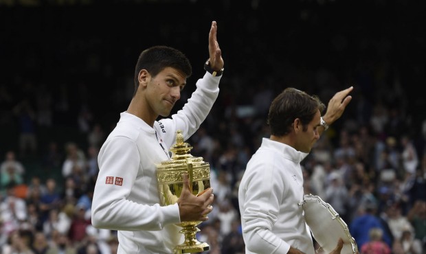 Novak Djokovic of Serbia, left, and Roger Federer of Switzerland hold their trophies after Djokovic...