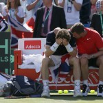 
              Britain's Andy Murray, left, sits with his head in his hands with Britain's captain Leon Smith after beating France's Gilles Simon, taking Britain to the semifinal stage, during the quarterfinal tennis matches of the Davis Cup at the Queen's Club in London, Sunday July 19, 2015. (AP Photo/Tim Ireland)
            
