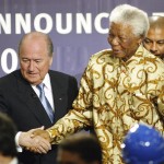 
              FILE - In this Saturday, May 15, 2004 file photo former South African President Nelson Mandela, right, is lead to the podium by FIFA President Sepp Blatter, of Switzerland, left, after learning that South Africa will host the 2010 FIFA World Cup, in Zurich, Switzerland.  (AP Photo/Michael Probst, File)
            