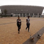 
              Women walk their dogs past the Cape Town Soccer stadium that hosted some games during the 2010 World Cup in Cape Town, South Africa, Thursday, May 28, 2015. The image of South Africa’s 2010 World Cup has been shattered by allegations that its bid over a decade ago was involved in bribes of more than $10 million to secure FIFA votes - possibly with the knowledge or involvement of the South African government. (AP Photo/Schalk van Zuydam)
            
