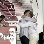 
              Leo Mancini,  second from left, , hugs his father Ray Mancini, after delivering a heartfelt speech about his father during the International Boxing Hall of Fame induction ceremony where Ray Mancini was inducted into the Hall of Fame, in Canastota, N.Y., Sunday, June 14, 2015. At left, Mancini's other son, Ray Mancini, Jr., looks on after delivering his own speech about his father. (AP photos/Heather Ainsworth)
            