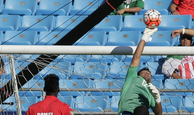 Guatemala goalkeeper Paulo Motta, top, stops a shot as Cuba’s Daniel Luis, left, and Guatemal...
