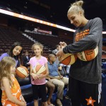 East's Elena Delle Donne, of the Chicago Sky, right, signs autographs for young fans before the WNBA All-Star basketball game against the West, Saturday, July 25, 2015, in Uncasville, Conn. (AP Photo/Jessica Hill)