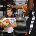 Lauren Ryan, 5, of Maplewood, N.J., looks up at East's Tamika Catchings, of the Indiana Fever, as she signs autographs before the WNBA All-Star basketball game, Saturday, July 25, 2015, in Uncasville, Conn. (AP Photo/Jessica Hill)
