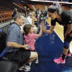 East's Sefanie Dolson, of the Washington Mystics, high fives Emma Fiedler, 4, of Middletown, as father Jason, left, looks on, before the WNBA All-Star basketball game, Saturday, July 25, 2015, in Uncasville, Conn. (AP Photo/Jessica Hill)
