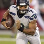 Seattle Seahawks quarterback Russell Wilson runs against the Arizona Cardinals during the first half of an NFL football game, Thursday, Oct. 17, 2013, in Glendale, Ariz. (AP Photo/Rick Scuteri)