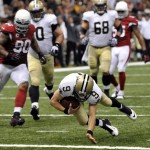 
New Orleans Saints quarterback Drew Brees (9) rushes for a touchdown in the second half of an NFL football game against the Arizona Cardinals in New Orleans, Sunday, Sept. 22, 2013. Saints wide receiver Lance Moore (16) and Cardinals cornerback Jerraud Powers (25) look on. (AP Photo/Bill Haber)