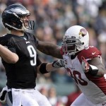 Philadelphia Eagles' Nick Foles, left, passes under pressure from Arizona Cardinals' Darnell Dockett during the first half of an NFL football game, Sunday, Dec. 1, 2013, in Philadelphia. (AP Photo/Michael Perez)