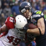 Seattle Seahawks tight end Zach Miller (86) is hit by Arizona Cardinals strong safety Rashad Johnson (49) as he scores on a 24-yard touchdown reception during the second quarter of an NFL football game in Seattle, Sunday, Dec. 9, 2012. (AP Photo/Stephen Brashear)
