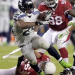 Seattle Seahawks running back Marshawn Lynch (24) breaks the tackle of Arizona Cardinals free safety Rashad Johnson (26) and defensive end Frostee Rucker during the second half of an NFL football game, Thursday, Oct. 17, 2013, in Glendale, Ariz. (AP Photo/Rick Scuteri)