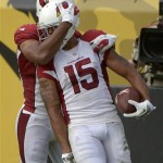 
Arizona Cardinals wide receiver Michael Floyd (15) is hugged by teammate Larry Fitzgerald, left, after scoring a touchdown on a 91-yard pass play during the second half of an NFL football game in Jacksonville, Fla., Sunday, Nov. 17, 2013. (AP Photo/Phelan M. Ebenhack)