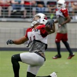 Arizona Cardinals' Larry Fitzgerald celebrates a touchdown catch as teammate Andre Roberts watches during NFL football training camp practice at University of Phoenix Stadium on Tuesday, July 30, 2013, in Glendale, Ariz. (AP Photo/Ross D. Franklin)