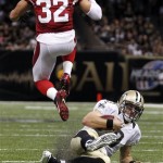 New Orleans Saints quarterback Drew Brees (9) slides under Arizona Cardinals defensive back Tyrann Mathieu (32) after carrying for a gain in the second half of an NFL football game in New Orleans, Sunday, Sept. 22, 2013. (AP Photo/Bill Haber)