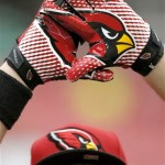 Arizona Cardinals fan Kevin Newinghas holds up his gloves during the team's practice at NFL football training camp, Friday, July 26, 2013, in Glendale, Ariz. (AP Photo/Matt York)