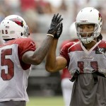 Arizona Cardinals' Larry Fitzgerald, right, gives Dan Buckner (85) a high-five after making a catch during the Cardinals' Red & White scrimmage at NFL football training campon Saturday, Aug. 3, 2013, in Glendale, Ariz. (AP Photo/Ross D. Franklin)
