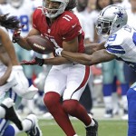 Arizona Cardinals wide receiver Larry Fitzgerald (11) makes a catch as Dallas Cowboys cornerback Brandon Carr defends during the first half of a preseason NFL football game on Saturday, Aug. 17, 2013, in Glendale, Ariz. (AP Photo/Rick Scuteri)