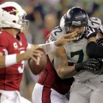 Arizona Cardinals quarterback Carson Palmer (3) is pressured by Seattle Seahawks defensive end Michael Bennett (72) during the first half of an NFL football game, Thursday, Oct. 17, 2013, in Glendale, Ariz. (AP Photo/Rick Scuteri)