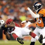 Arizona Cardinals wide receiver Kerry Taylor is knocked off his feet by Denver Broncos cornerback Kayvon Webster (36) after a reception during the first quarter of a preseason NFL football game, Thursday, Aug. 29, 2013, in Denver. (AP Photo/Jack Dempsey)