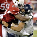 Seattle Seahawks quarterback Russell Wilson, right, takes a hit from Arizona Cardinals inside linebacker Daryl Washington during the first half of an NFL football game, Thursday, Oct. 17, 2013, in Glendale, Ariz. (AP Photo/Ross D. Franklin)