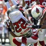 Tampa Bay Buccaneers running back Doug Martin (22) is sent flying on a hit by Arizona Cardinals defensive back Tyrann Mathieu (32) and strong safety Yeremiah Bell (37) during the first quarter of an NFL football game Sunday, Sept. 29, 2013, in Tampa, Fla. (AP Photo/Brian Blanco)