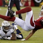 Arizona Cardinals' Larry Fitzgerald, right, gets upended by San Diego Chargers' Johnny Patrick (26) in the first half of a preseason NFL football game on Saturday, Aug. 24, 2013, in Glendale, Ariz. (AP Photo/Ross D. Franklin)