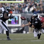 Philadelphia Eagles' Nick Foles (9) tosses to LeSean McCoy (25) as he is tackled by Arizona Cardinals' Dan Williams (92) and Frostee Rucker (98) during the first half of an NFL football game on Sunday, Dec. 1, 2013, in Philadelphia. (AP Photo/Michael Perez)