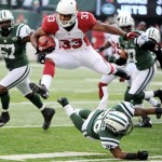 Arizona Cardinals running back William Powell (33) leaps over New York Jets defensive back Ellis Lankster during the second half of an NFL football game, Sunday, Dec. 2, 2012, in East Rutherford, N.J. (AP Photo/Bill Kostroun)