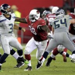 Seattle Seahawks quarterback Russell Wilson (3) throws under pressure from Arizona Cardinals defensive end Frostee Rucker (98) during the second half of an NFL football game, Thursday, Oct. 17, 2013, in Glendale, Ariz. (AP Photo/Rick Scuteri)

