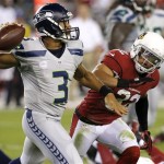 Seattle Seahawks quarterback Russell Wilson (3) scrambles as Arizona Cardinals free safety Tyrann Mathieu defends during the first half of an NFL football game, Thursday, Oct. 17, 2013, in Glendale, Ariz. (AP Photo/Ross D. Franklin)
