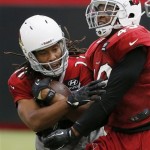 Arizona Cardinals' Larry Fitzgerald, left, and Rashad Johnson collide as Fitzgerald makes a catch at NFL football training camp practice on Monday, Aug. 5, 2013, in Glendale, Ariz. (AP Photo/Ross D. Franklin)