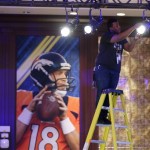 Dapo Adebgoyega adjusts a light on radio row at the NFL Super Bowl XLVIII media center, Monday, Jan. 27, 2014, in New York. The NFL's championship football game between the Denver Broncos and Seattle Seahawks is scheduled for Sunday, Feb. 2 in East Rutherford, N.J. (AP Photo/Matt Slocum)