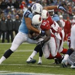 Arizona Cardinals running back Rashard Mendenhall (28) pushes past Tennessee Titans defensive end Ropati Pitoitua (92) as Mendenhall scores a touchdown on a 1-yard run in the first quarter of an NFL football game Sunday, Dec. 15, 2013, in Nashville, Tenn. (AP Photo/Wade Payne)