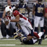 Arizona Cardinals' Larry Fitzgerald (11) is tackled by St. Louis Rams' Trumaine Johnson (22) during the second half of an NFL football game Thursday, Dec. 11, 2014 in St. Louis. (AP Photo/Jeff Roberson)