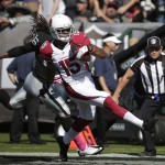 Arizona Cardinals wide receiver Michael Floyd (15) scores on a 33-yard touchdown reception past Oakland Raiders free safety Usama Young (26) during the second quarter of an NFL football game in Oakland, Calif., Sunday, Oct. 19, 2014. (AP Photo/Marcio Jose Sanchez)