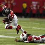 Atlanta Falcons free safety Dwight Lowery (20) runs by Arizona Cardinals running back Andre Ellington (38) after Lowery intercepted a passed ball during the first half of an NFL football game, Sunday, Nov. 30, 2014, in Atlanta. (AP Photo/John Bazemore)