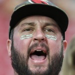 An Arizona Cardinals fan shouts for his team as they warm up as he wears Salute To Service eye black prior to an NFL football game between the Cardinals and the St. Louis Rams on Sunday, Nov. 9, 2014, in Glendale, Ariz. (AP Photo/Ross D. Franklin)