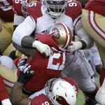 San Francisco 49ers running back Frank Gore (21) is tackled by Arizona Cardinals defensive end Tommy Kelly (95) and nose tackle Dan Williams (92) during the third quarter of an NFL football game in Santa Clara, Calif., Sunday, Dec. 28, 2014. (AP Photo/Marcio Jose Sanchez)
