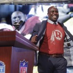 
Former Washington Redskins linebacker London Fletcher flashes a Redskins shirt under his jacket before announcing Stanford's Trent Murphy as the 47th selection by the Redskins for the second round of the 2014 NFL Draft, Friday, May 9, 2014, in New York. (AP Photo/Jason DeCrow)