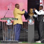 Hall of Fame Inductee Derrick Brooks, left, with the help of his son and presenter Decalon Brooks, uncover his bronze bust during the 2014 Pro Football Hall of Fame Enshrinement Ceremony at the Pro Football Hall of Fame Saturday, Aug 2, 2014 in Canton, Ohio. (AP Photo/David Richard)