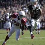 Oakland Raiders wide receiver Brice Butler (12) catches a pass in front of Arizona Cardinals free safety Rashad Johnson (26) during the second quarter of an NFL football game in Oakland, Calif., Sunday, Oct. 19, 2014. (AP Photo/Marcio Jose Sanchez)