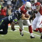 Seattle Seahawks defensive end Cliff Avril, left, sacks Arizona Cardinals quarterback Drew Stanton (5) in the first half of an NFL football game, Sunday, Nov. 23, 2014, in Seattle. (AP Photo/Elaine Thompson)