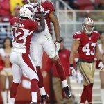 Arizona Cardinals wide receiver Michael Floyd, top, celebrates after scoring on a 41-yard touchdown reception with wide receiver John Brown (12) in front of San Francisco 49ers strong safety Craig Dahl (43) during the second quarter of an NFL football game in Santa Clara, Calif., Sunday, Dec. 28, 2014. (AP Photo/Tony Avelar)
