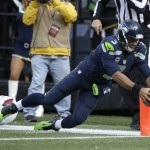 Seattle Seahawks quarterback Russell Wilson makes a long run to out of bounds near the end zone that was called back on a holding penalty in the first half of an NFL football game against the Arizona Cardinals, Sunday, Nov. 23, 2014, in Seattle. (AP Photo/Elaine Thompson)