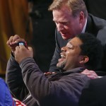NFL commissioner Roger Goodell poses for a photo with a fan before the start of the second round of the 2014 NFL Draft, Friday, May 9, 2014, in New York. (AP Photo/Jason DeCrow)