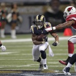 St. Louis Rams' Tre Mason (27) runs out of the tackle of Arizona Cardinals outside linebacker Alex Okafor (57) during the first half of an NFL football game Thursday, Dec. 11, 2014 in St. Louis. (AP Photo/Tom Gannam)