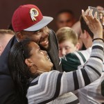 Virginia tackle Morgan Moses poses for photos with a fan after being selected as the 66th pick by the Washington Redskins during the third round of the 2014 NFL Draft, Friday, May 9, 2014, in New York. (AP Photo/Jason DeCrow)
